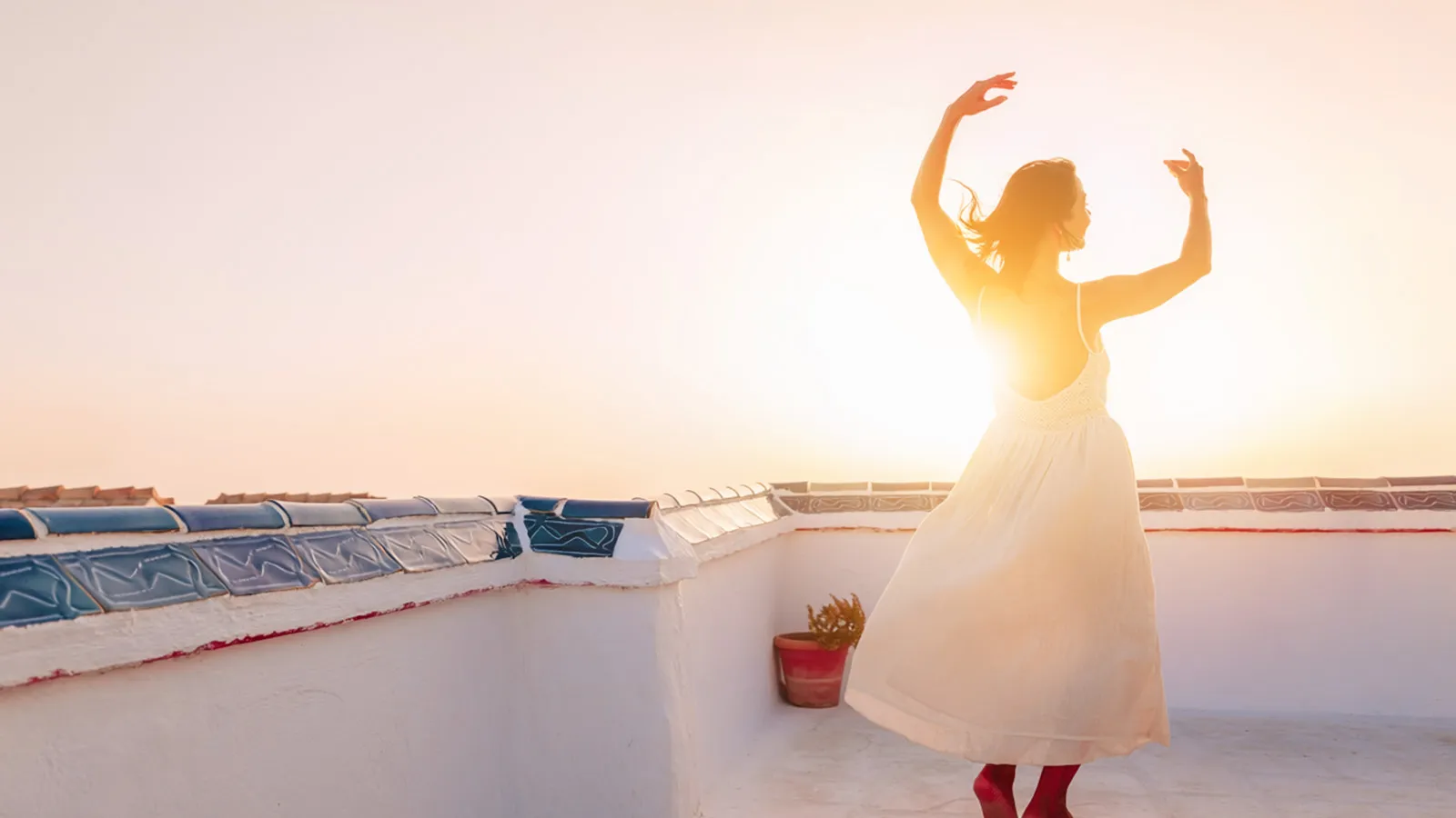 woman-dancing-rooftop-sunset-white-dress-larios